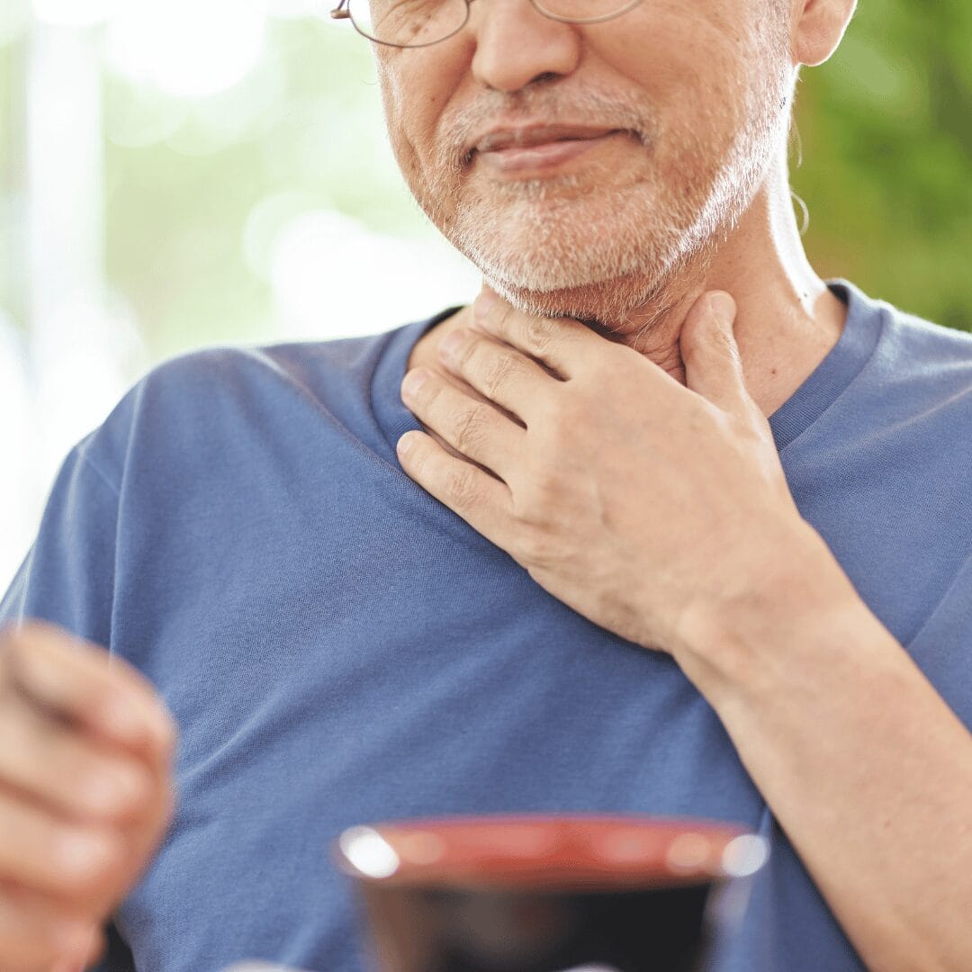 Man holding throat in pain